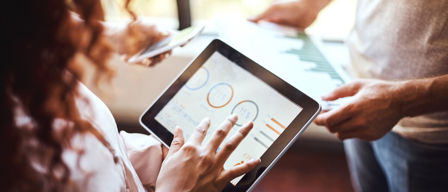 Two people looking at data on screens
